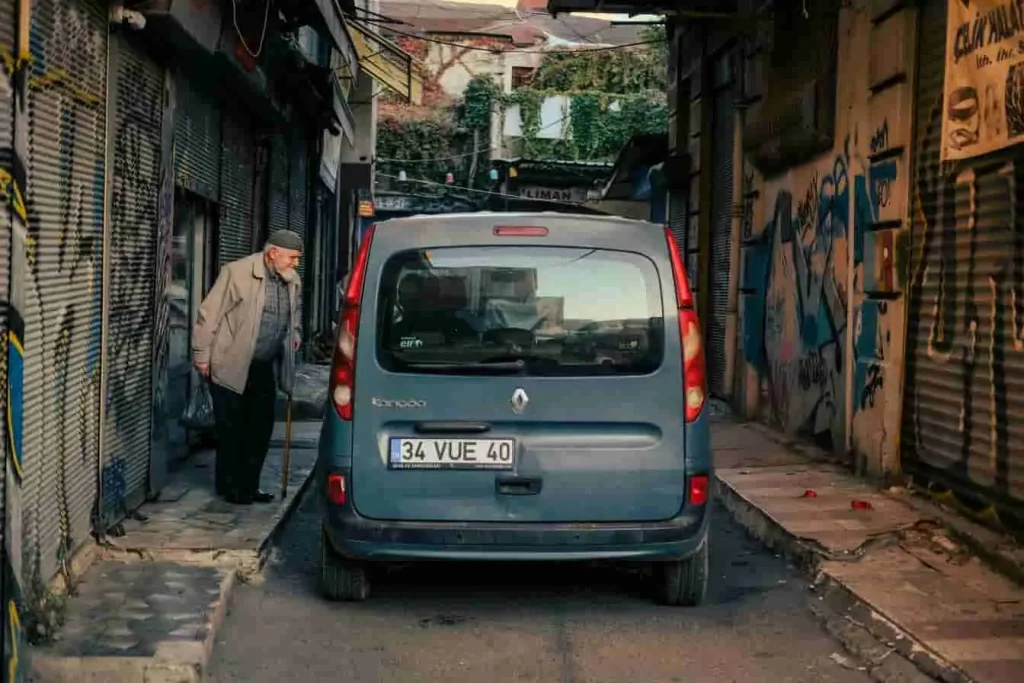 Renault Kangoo bleu garé dans une ruelle urbaine, symbole de fiabilité et d’adaptabilité dans les environnements étroits et complexes.