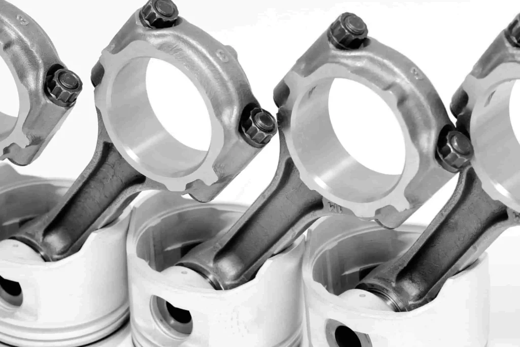 Assemblage piston-bielle en métal, zones circulaires prêtes à accueillir un coussinet de bielle, fond technique.