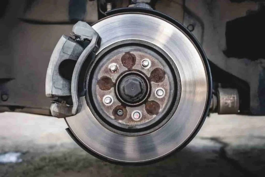 Système de frein à disque avec rotor circulaire et étrier fixé sur moyeu, image qui reflète une pièce essentielle du frein de service automobile