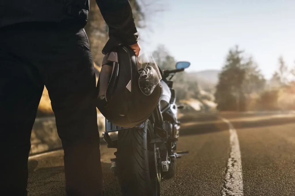 Silhouette en équipement moto à côté d’une Honda Hornet S 600, ambiance balade et liberté