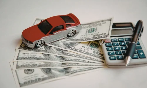 Voiture miniature sur billets de banque illustrant une simulation de rachat de crédit au
