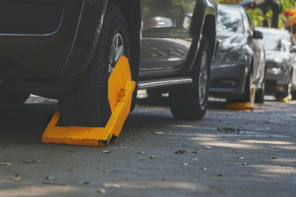 Rangée de voitures immobilisées par des sabots jaunes, sanction visible pour stationnement interdit en zone urbaine