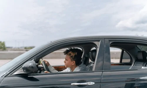 Conducteur assis au volant d’une voiture sombre, image évoquant les risques liés à la fatigue qui réduit la vigilance et augmente le danger sur la route.