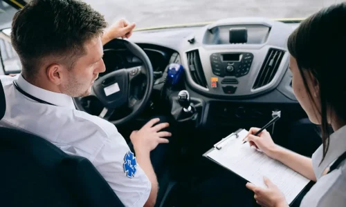 Conducteur et collègue assis dans un véhicule remplissent un document, image évoquant le certificat médical nécessaire pour obtenir un permis de conduire.