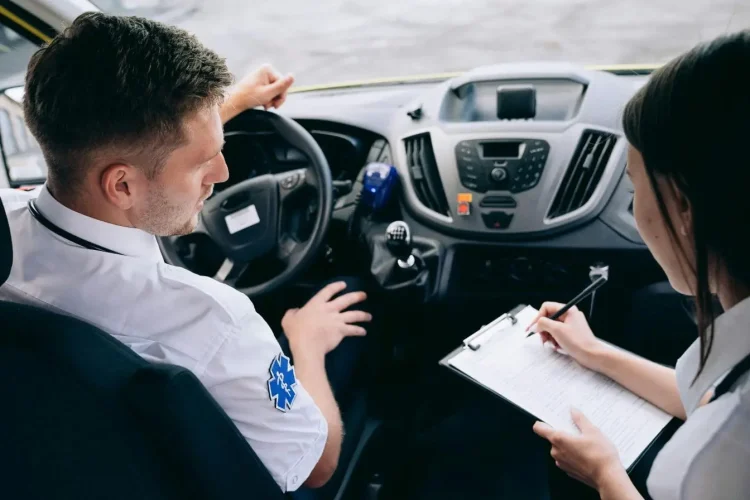 Conducteur et collègue assis dans un véhicule remplissent un document, image évoquant le certificat médical nécessaire pour obtenir un permis de conduire.