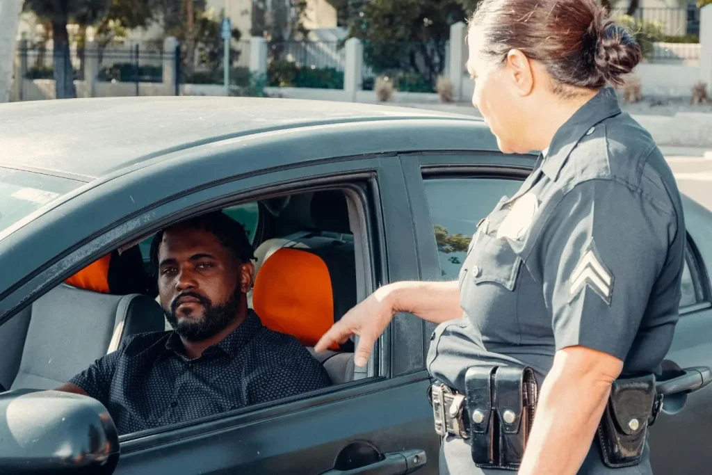 Policier en uniforme échange avec conducteur, image illustrant un contrôle de police et l’importance de connaître ses droits et d’adopter un comportement respectueux.