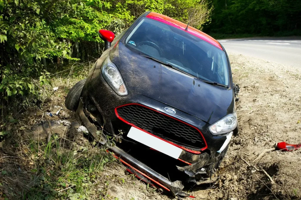 Voiture accidentée sortie de route, image illustrant les conséquences d’une distraction liée à l’usage du téléphone au volant.