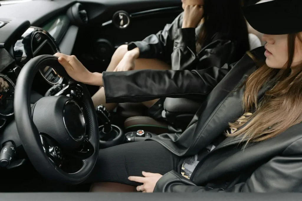 Personne assise au volant d’une voiture, image illustrant la conduite accompagnée et l’apprentissage progressif de la maîtrise du véhicule.
