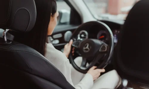 Personne assise au volant d’une voiture, image illustrant la conduite accompagnée et l’apprentissage progressif de la maîtrise du véhicule.