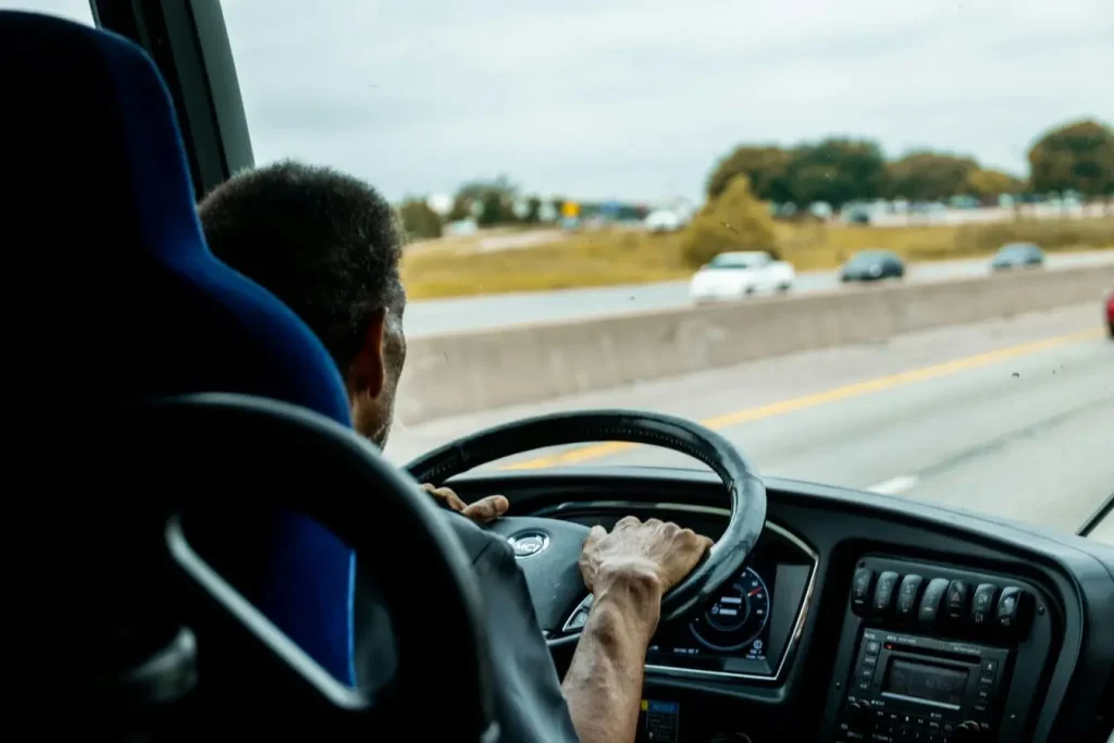 Vue arrière d’un conducteur de bus sur autoroute, image illustrant le convoyage de voiture et la gestion des trajets routiers.