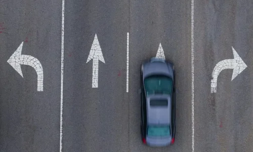 Vue aérienne d’une route à trois voies avec flèches directionnelles, image illustrant la règle de priorité à droite dans la circulation.