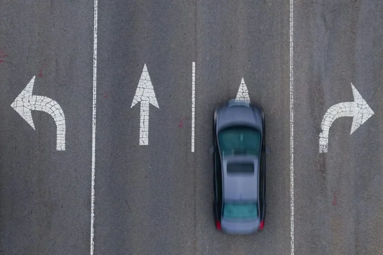 Vue aérienne d’une route à trois voies avec flèches directionnelles, image illustrant la règle de priorité à droite dans la circulation.