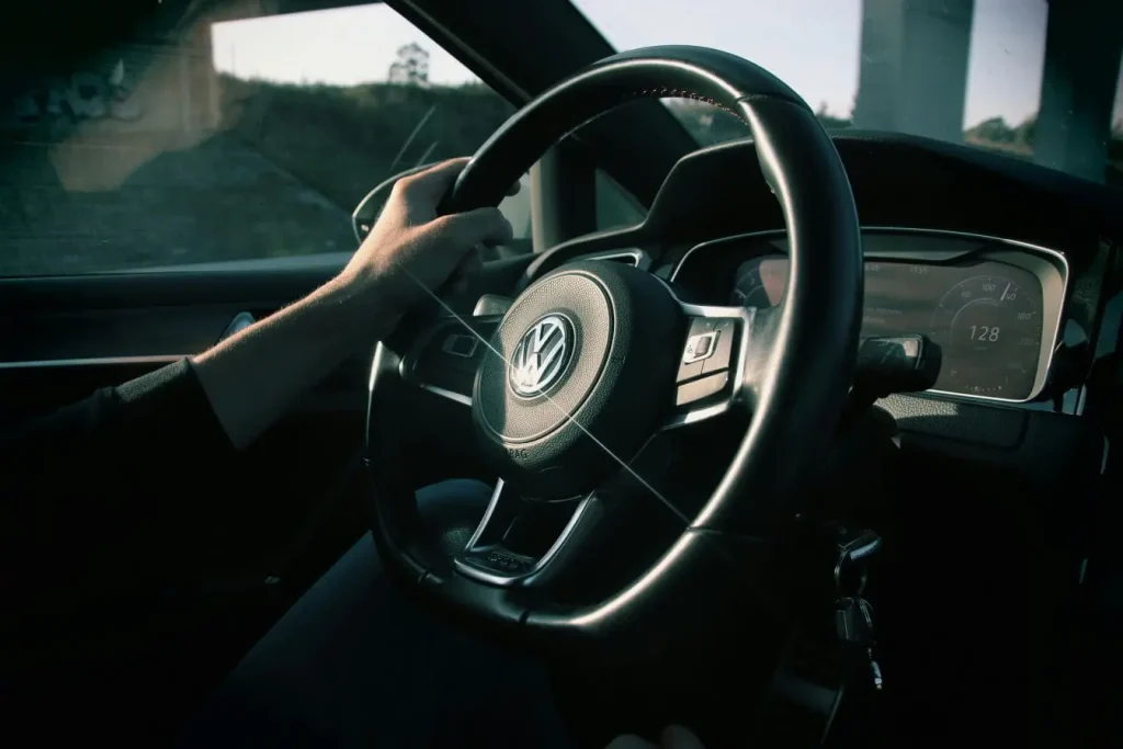 Main serrant le volant d’une voiture à 128 km/h, image évoquant les risques de la fatigue qui réduit la vigilance et augmente le danger routier.