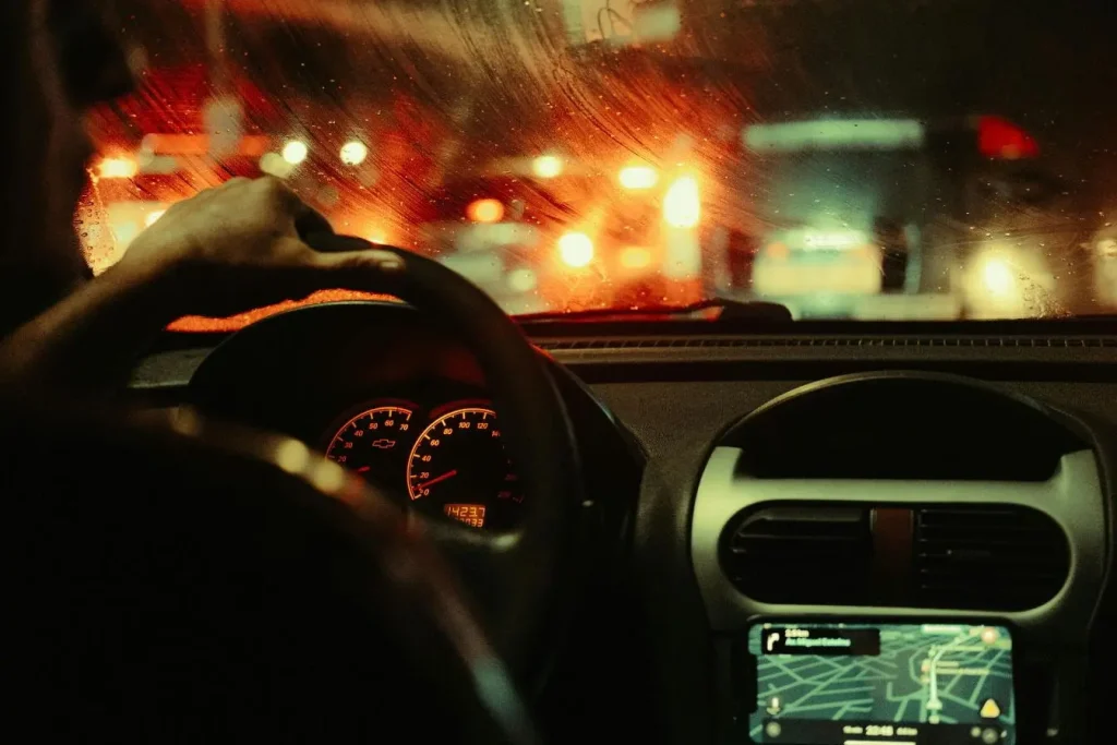 Intérieur de voiture la nuit avec tableau de bord éclairé, image illustrant dans quels cas utiliser ses feux de route.