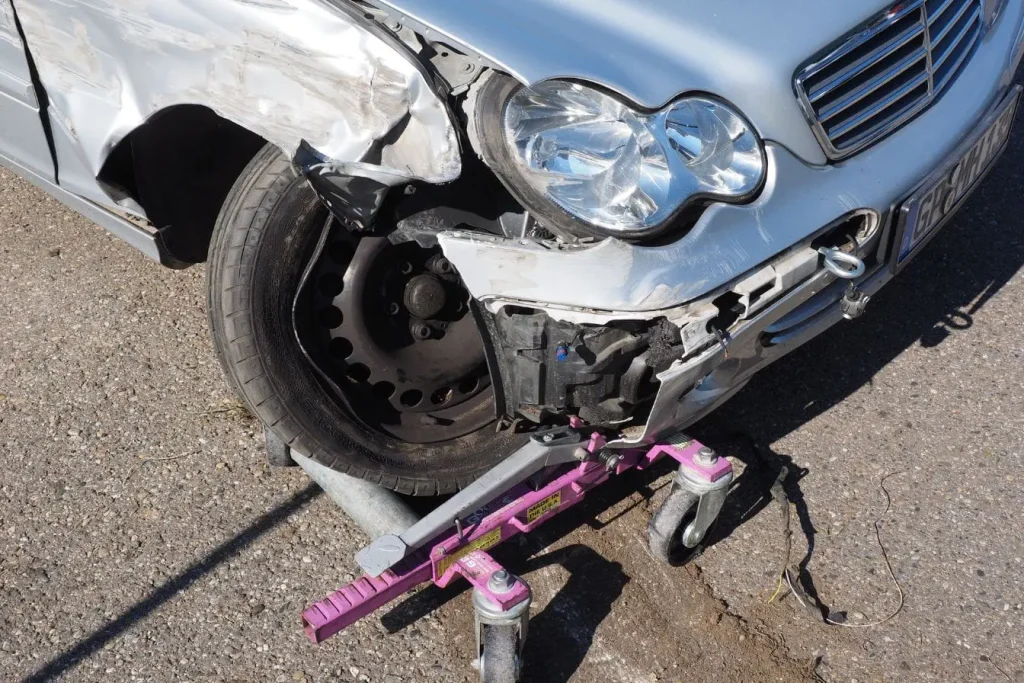 Voiture endommagée sur roue de secours, image illustrant les situations où un véhicule de remplacement peut être demandé selon conditions d’assurance.