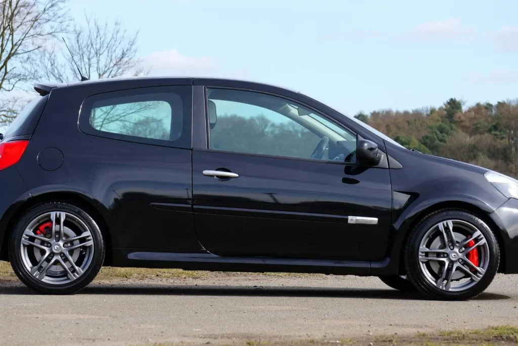 Voiture noire garée sur sol pavé reflétant l’importance de la garantie des vices cachés pour protéger l’acheteur contre défauts invisibles.
