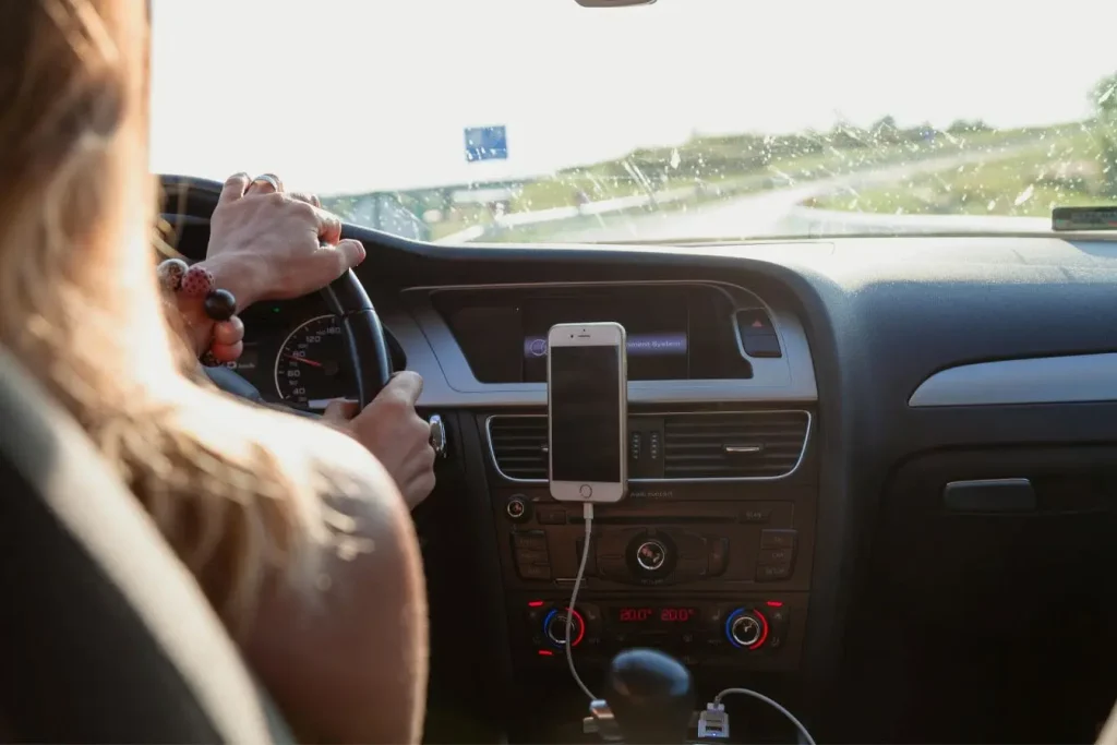 Conducteur tenant fermement le volant sur autoroute ensoleillée, image évoquant la question de l’âge minimum pour conduire sans permis.