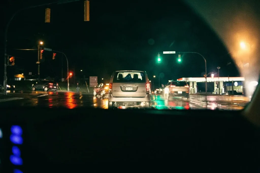 Circulation urbaine sous pluie avec SUV argenté, scène évoquant les situations où activer ses feux de route.