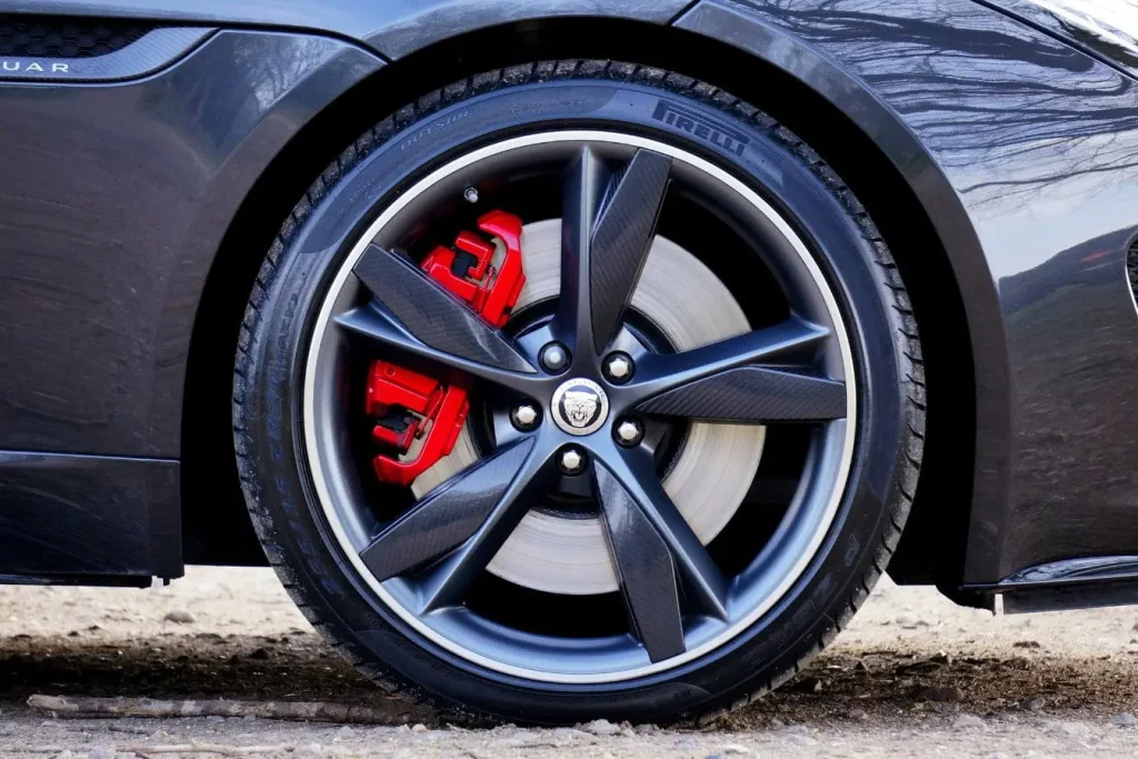 Gros plan sur roue Jaguar avec pneu Pirelli et étrier rouge, image illustrant l’indice de vitesse de pneu et ses performances sportives.