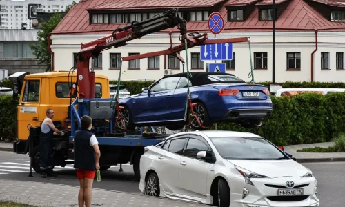 Remorquage de voiture entre particuliers représenté par une grue hydraulique plaçant un cabriolet sur un plateau de dépannage.