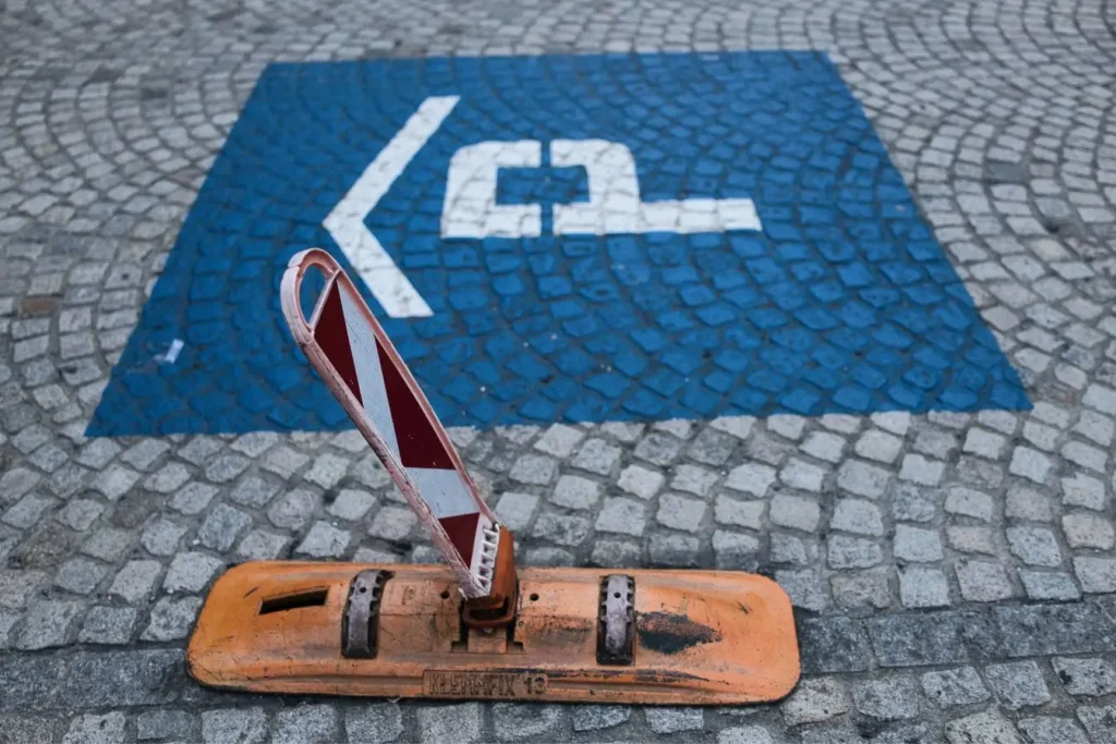 Pavé en pierre avec carré bleu marqué d’un symbole de voiture et flèche, image qui illustre le fonctionnement de la zone bleue et l’usage du disque de stationnement.