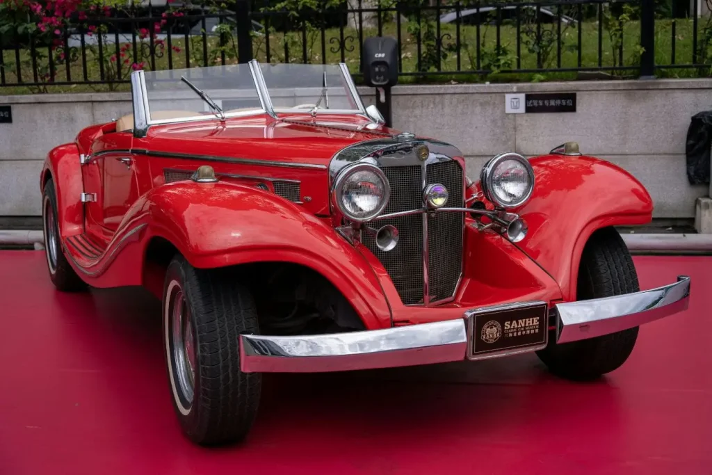 Cabriolet rouge ancien exposé sur sol coloré, image qui illustre la passion et les démarches liées à la carte grise de collection.