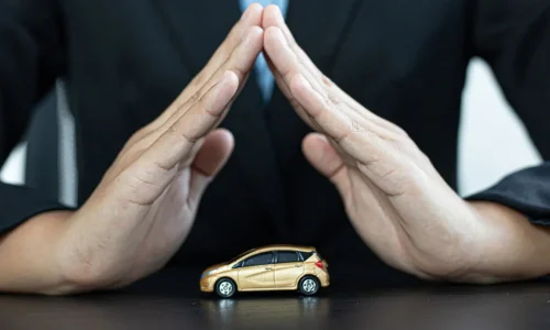 Mains en geste protecteur au-dessus d’une petite voiture dorée, image qui illustre l’assurance auto Black Box et la sécurité des conducteurs.