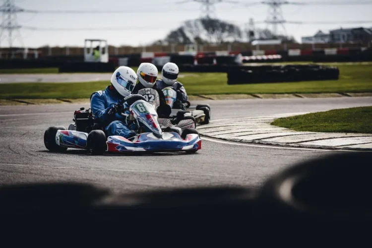 Trois pilotes en combinaison et casque roulent sur piste, image illustrant les débuts en karting adulte et la progression sur circuit.