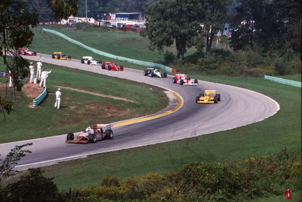 Plusieurs voitures de course négocient virage serré sur circuit, image illustrant l’ambiance d’une journée circuit et la préparation nécessaire.