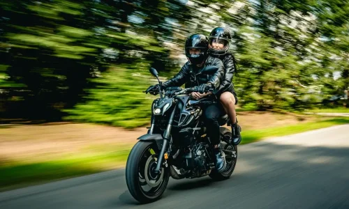 Motards en casques noirs tenant fermement guidon, image qui traduit la technique du frein moteur.