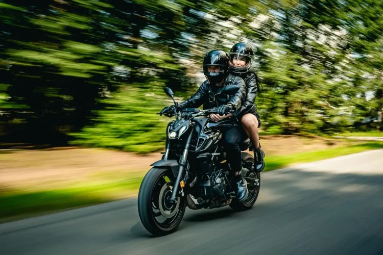 Motards en casques noirs tenant fermement guidon, image qui traduit la technique du frein moteur.