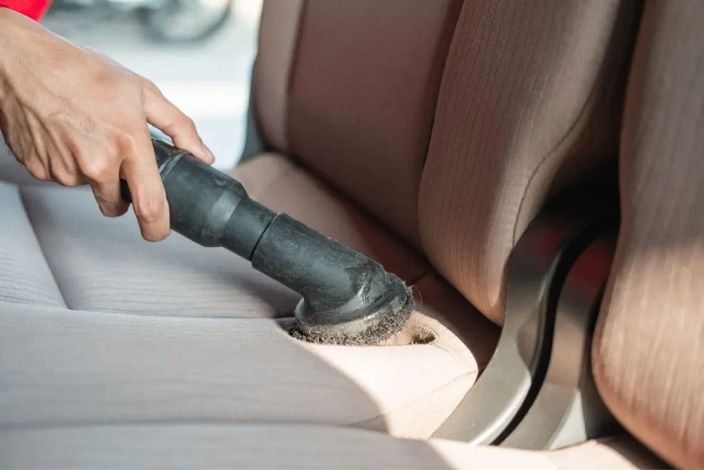 Siège beige nettoyé avec aspirateur, illustration typique des causes et solutions face à une odeur suspecte.