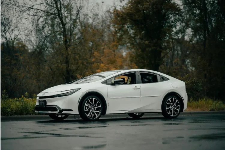 Voiture élégante aux phares affûtés posée sur sol mouillé, reflet des besoins spécifiques d’entretien d’une hybride rechargeable.