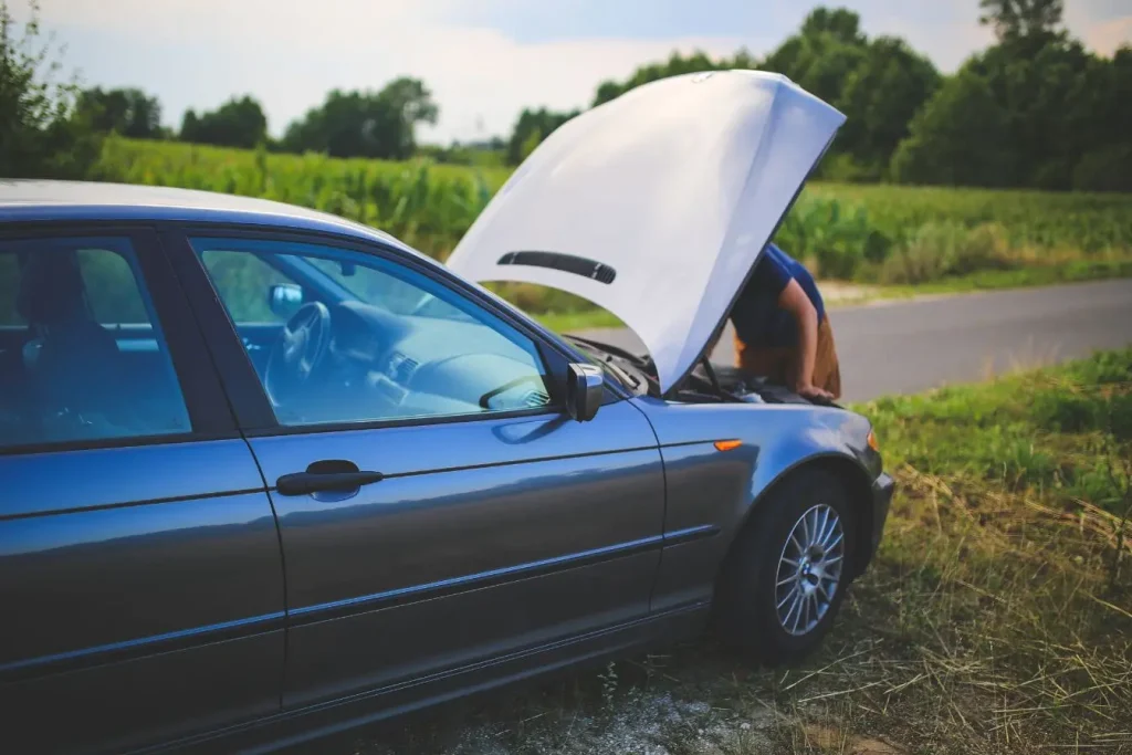 Voiture arrêtée avec capot ouvert, illustration représentative des causes principales de perte de puissance.