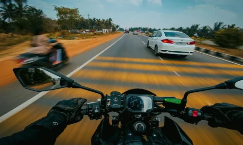 Vue pilote sur moto avec route et voitures, reflet des signes d’un embrayage qui patine et des solutions mécaniques.
