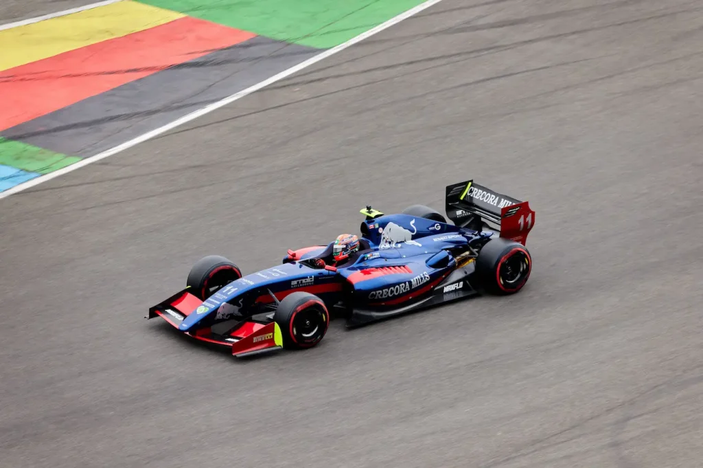 Voiture de course bleue numéro 11 filant sur circuit, image qui illustre le classement des pilotes de F1 en fin de saison et l’attribution du titre.