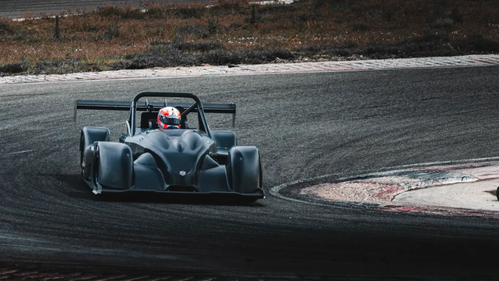 Voiture de course noire filant sur circuit, image qui illustre le salaire moyen d’un pilote de course et la réalité derrière la vitesse.