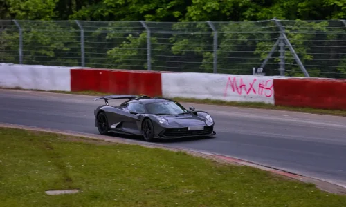 Voiture de sport gris foncé filant sur circuit, image qui illustre le record du tour au Nürburgring.