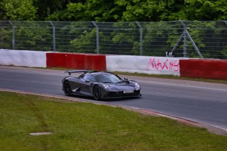 Voiture de sport gris foncé filant sur circuit, image qui illustre le record du tour au Nürburgring.