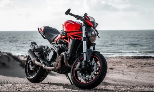 Vue arrière d’une moto sportive sur sable, image claire illustrant combien de temps une batterie moto peut durer.