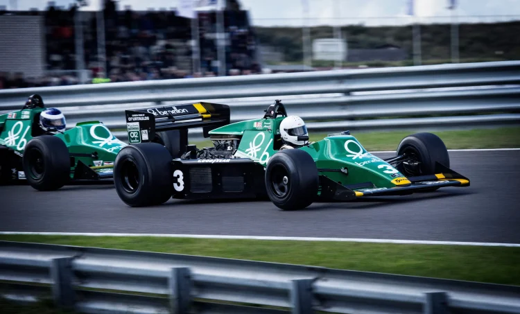Deux voitures de course vintage sur piste, illustration du classement des pilotes de F1 et de la fin de saison.