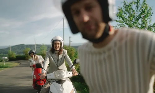 Deux personnes en scooter sur route verdoyante, reflet des questions liées au tarif d’une assurance scooter 125.