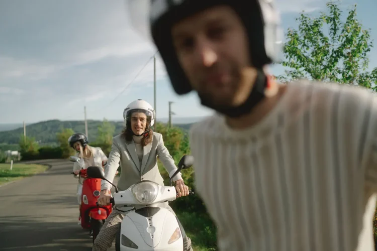 Deux personnes en scooter sur route verdoyante, reflet des questions liées au tarif d’une assurance scooter 125.