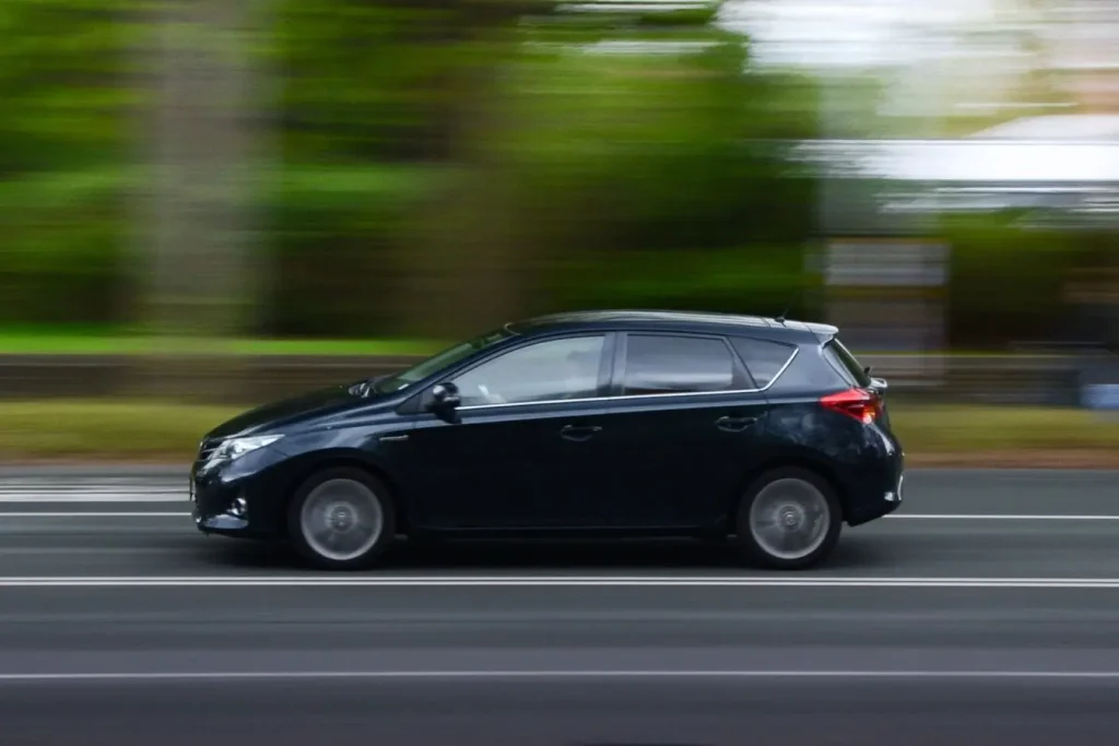 Gros plan sur voiture en déplacement, image représentative d’un sifflement lié à vitesse constante.