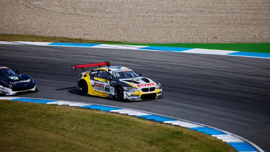 Deux voitures de course filant sur piste asphaltée, image qui évoque le record du tour au Nürburgring.