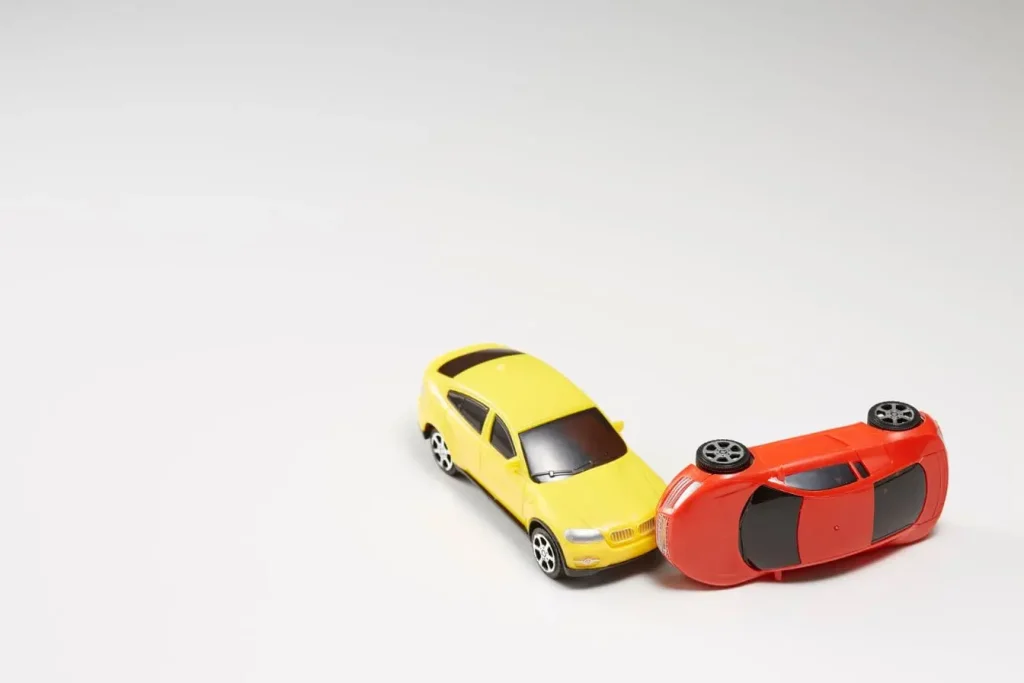 Deux voitures miniatures en collision, reflet d’un rapport d’expertise pour comprendre les dommages d’un véhicule accidenté.